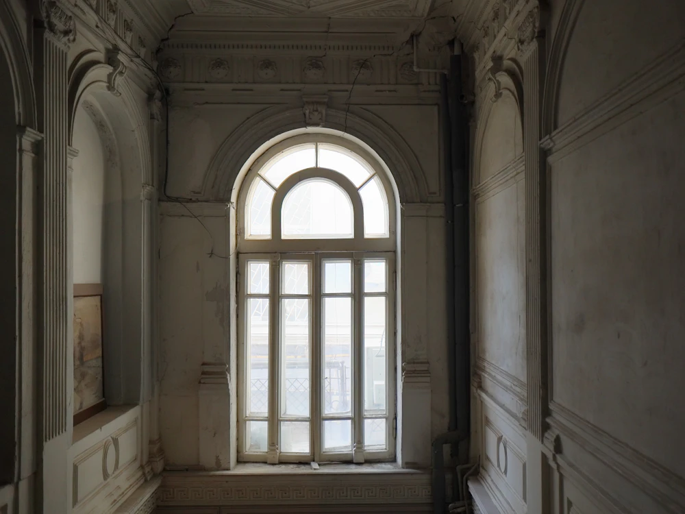 Janela em arco numa casa antiga, com paredes trabalhadas