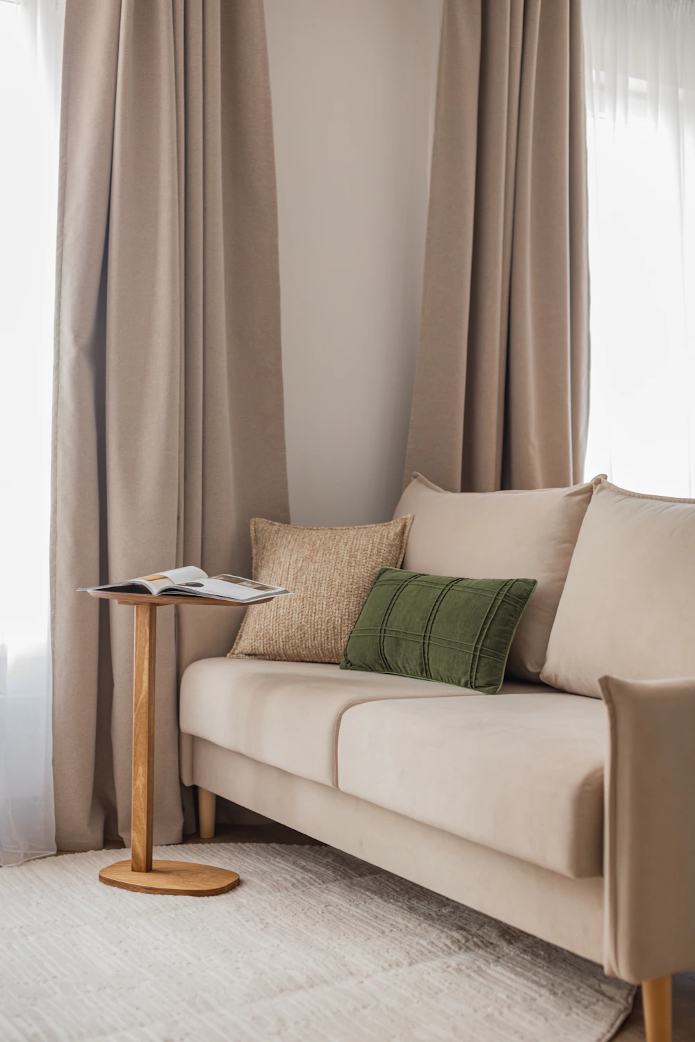 Sala pronta a viver, com sofá claro e cortinas de linho